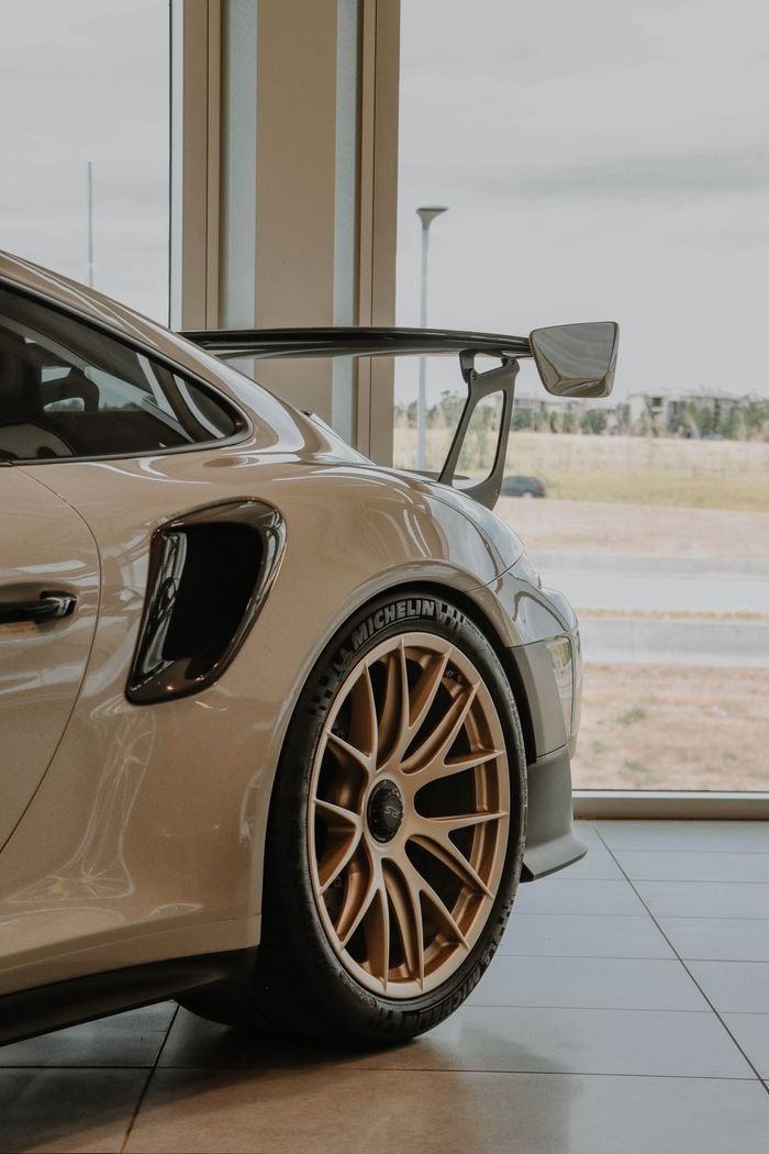 Close-up of a white sports car in a showroom setting, showcasing elegant design.