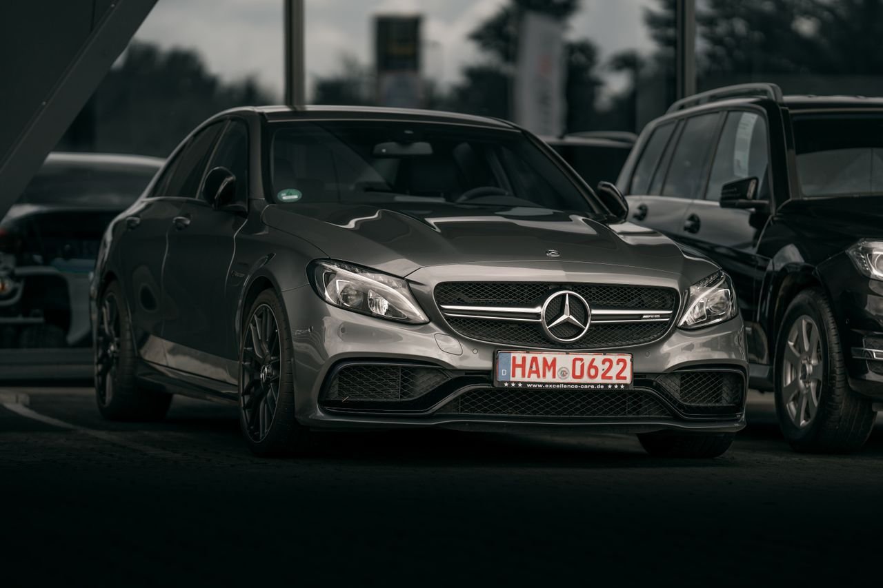 Elegant silver luxury car parked in a city setting, showcasing sleek design and modern style.